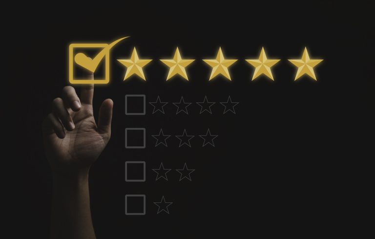 A hand ticking the top five-star option on a dark rating scale