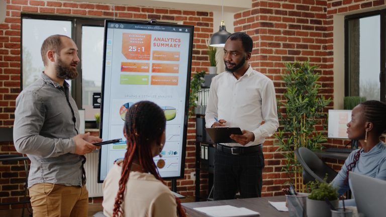 Business team reviewing an analytics summary on a large screen during a presentation